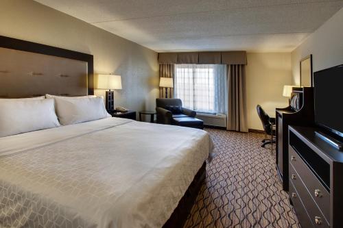a hotel room with a large bed and a chair at Holiday Inn Express Baltimore BWI Airport West by IHG in Hanover
