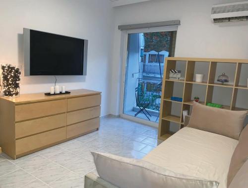een woonkamer met een tv en een bank bij Treasure cosy flat in Athene