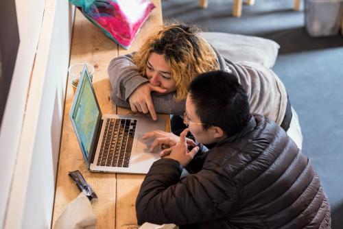 a woman and a man looking at a laptop on a table at Sleep in Heaven in Copenhagen