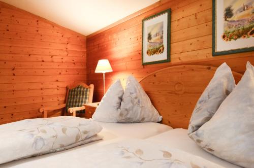 a bedroom with two beds in a room with wooden walls at Ferienhaus Schnitzhof in Abtenau