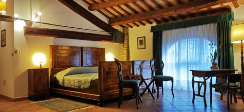 - une chambre avec un lit, une table et des chaises dans l'établissement Agriturismo-R&B Corte dei Gioghi, à Ferrare