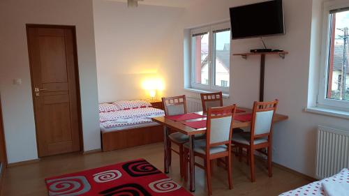 Villa Lienka في بشنوفا: غرفة طعام مع طاولة وكراسي وغرفة نوم