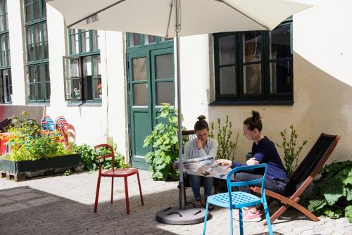 two women sitting at a table under an umbrella at Sleep in Heaven in Copenhagen