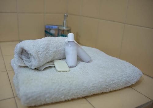 a white towel with a bottle of soap and a razor at AMANECER Rent Apart - Tú Hogar! Amplio y Luminoso con Desayuno in Junín