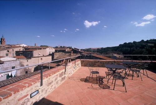 a patio with tables and chairs on top of a building at La Torre in Asciano