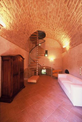 a living room with a couch and a spiral staircase at La Torre in Asciano
