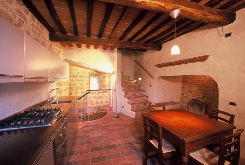 a kitchen with a wooden table and a brick wall at La Torre in Asciano