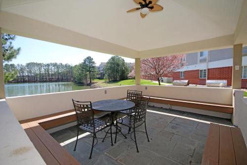 a patio with a table and chairs and a view of a lake at Candlewood Suites Newport News-Yorktown by IHG in Newport News