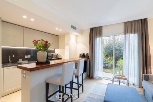 cocina y sala de estar con barra con taburetes en Villa Artemys - Five Stars Holiday House, en Saint-Jean-Cap-Ferrat