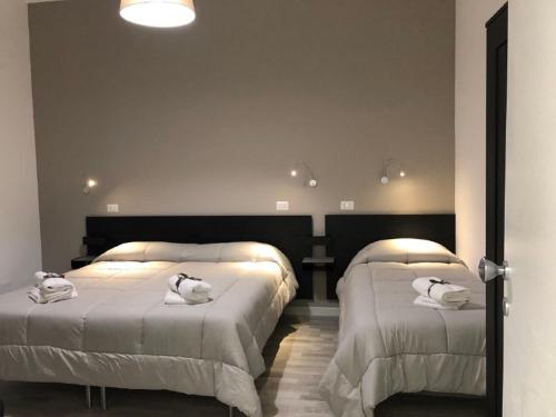 a bedroom with two beds with white towels on them at La Maison in Acquaviva delle Fonti
