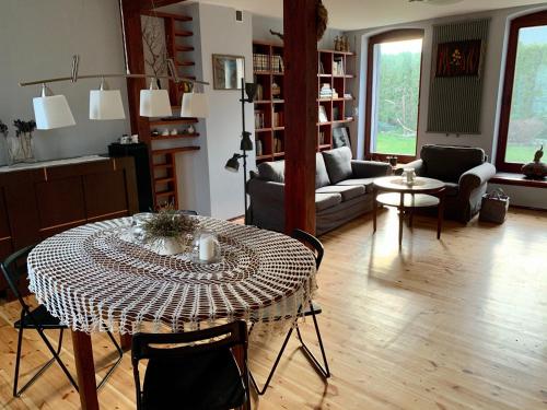 a living room with a table and a couch at Stara Stodola / Old Barn in Gardna Wielka