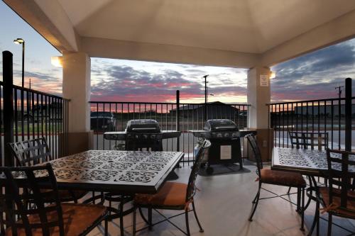 a patio with tables and chairs and a grill at Candlewood Suites Odessa by IHG in Odessa