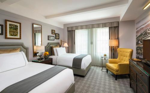 a hotel room with two beds and a chair at InterContinental New York Barclay Hotel by IHG in New York
