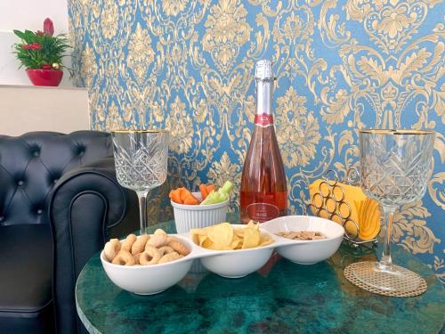 un tavolo con ciotole di cibo e una bottiglia di vino di Dimora San Biagio Suites&Apartment a Lecce