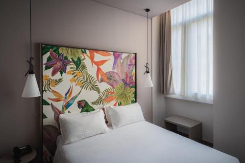 sypialnia z białym łóżkiem i obrazem na ścianie w obiekcie Hotel San Giovanni Roma w Rzymie