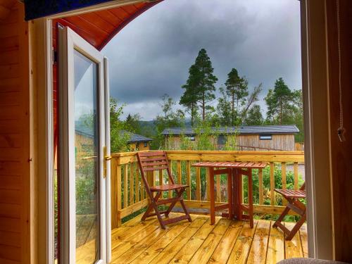 a balcony with a table and chairs on a deck at Tarbert Holiday Park in Tarbert