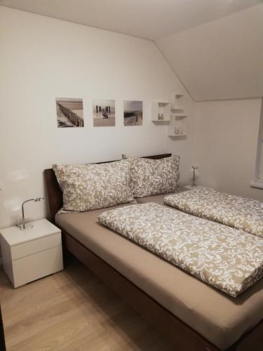 a bedroom with a bed and a white wall at Ferienwohnung Auszeit in Dornbirn