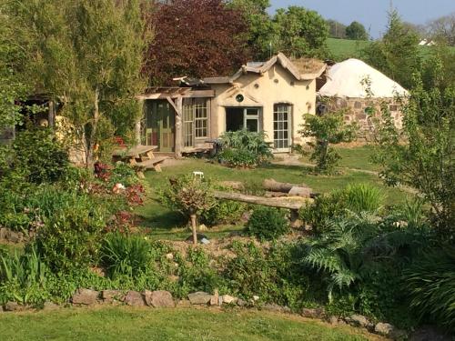 una casa con un jardín delante de ella en Inch Hideaway Eco Camping, en Whitegate