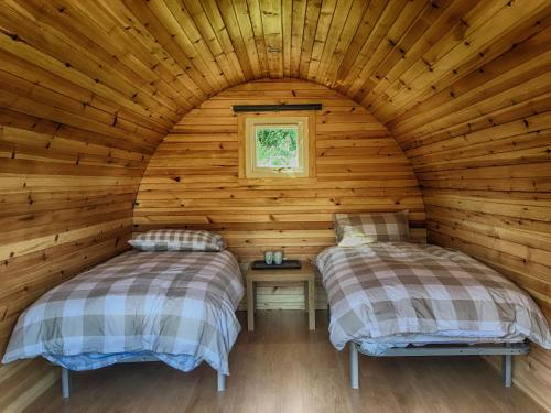 a log cabin with two beds in a room at Tarbert Holiday Park in Tarbert