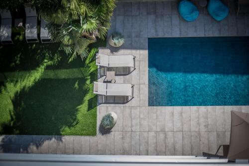 an overhead view of a swimming pool with chairs and a lawn at Hotel Villa Enrica in Riva del Garda