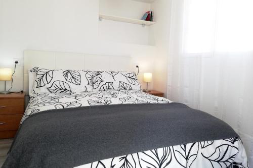 トレ・デル・マールにあるAtico del Marのベッドルーム1室(ベッド1台、白黒のシーツ、枕付)
