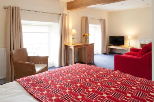 a hotel room with a red bed and a red chair at Y Talbot in Tregaron