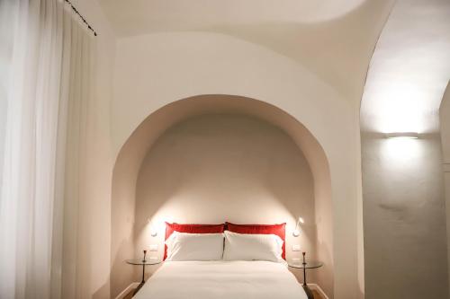 1 Schlafzimmer mit einem weißen Bett und einem Torbogen in der Unterkunft Il Loggiato by Wonderful Italy in Neapel