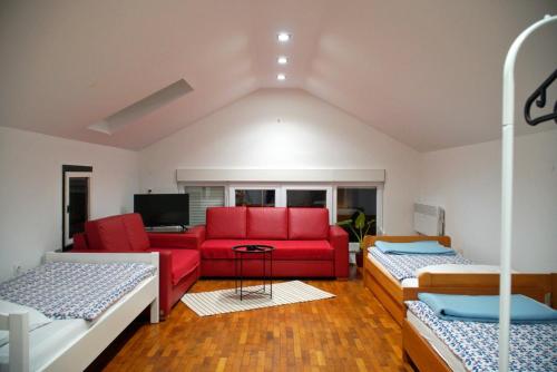 ein Wohnzimmer mit einem roten Sofa und 2 Betten in der Unterkunft Apartments Nera in Zagreb