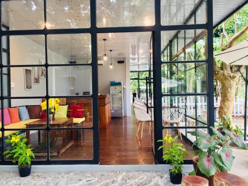 a room with large windows and a table and chairs at Eden House & Coffee Con Dao in Con Dao