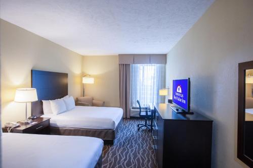 una camera d'albergo con due letti e una televisione di Americas Best Value West Point a West Point