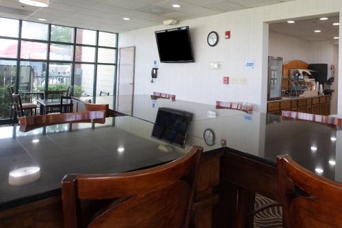 a waiting room with a table and chairs and a tv at Americas Best Value West Point in West Point