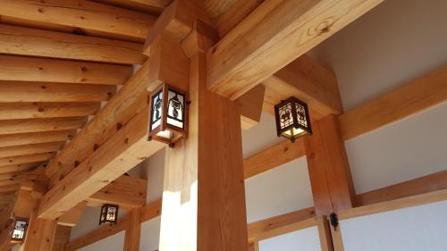 aamed ceilings in a timber house with lights at SiEunJae in Gyeongju