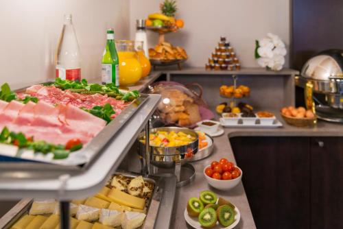 a buffet with meat and vegetables and other foods at Hôtel Le Marquis by Inwood Hotels in Paris