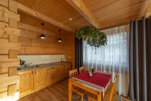 a kitchen with a table and a dining room at Apartamenty WILLA OLSZA wood house & mountain view & sauna in Zakopane