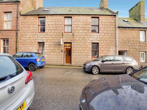 three cars parked in front of a brick building at Lost Guest House Peterhead in Peterhead