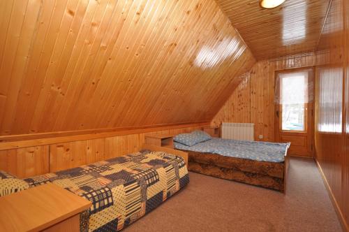 a room with two beds in a wooden cabin at House in the valley in Kościelisko