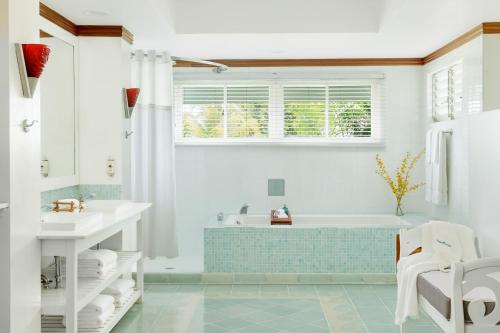 a bathroom with a tub and a sink at Couples Negril in Negril