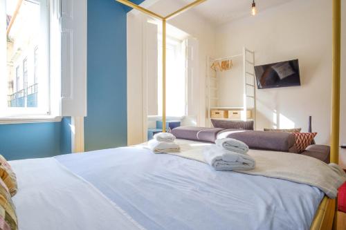 1 dormitorio con 1 cama con toallas en Colourful Alfama Apartment en Lisboa
