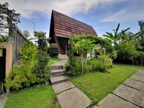 dom z ogrodem z ścieżką prowadzącą do niego w obiekcie Telagamas Guest House w mieście Banjarangkan