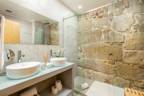baño con lavabo y pared de piedra en YOUROPO - Ribeira Gaia en Vila Nova de Gaia