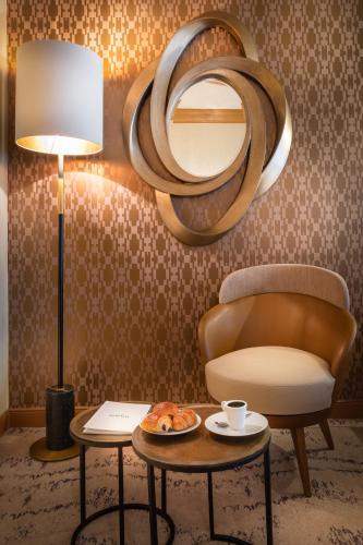 a room with a chair and a table with a plate of food at Hôtel le Derby Alma by Inwood Hotels in Paris