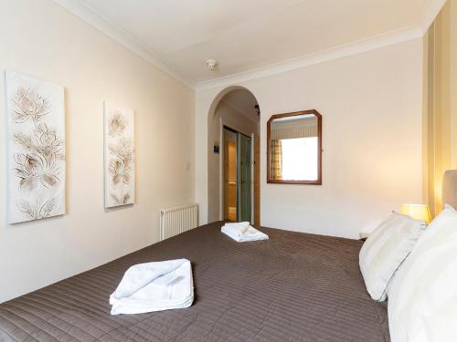 um quarto com toalhas brancas numa cama em OYO Arden Guest House, Craigmillar Castle Edinburgh em Edinburgo