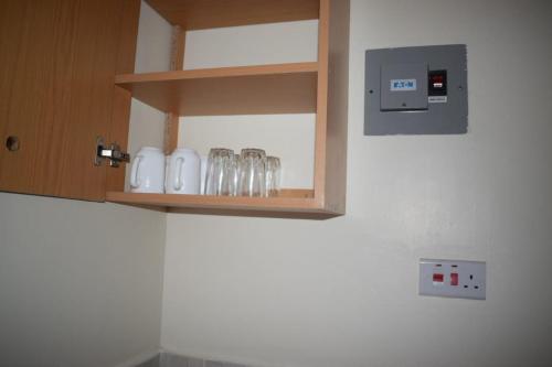 a row of glasses on a shelf in a kitchen at Marya Shelters Limited in Mombasa