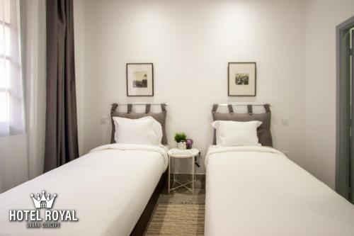two beds sitting next to each other in a room at Hôtel Royal Urban Concept in Fez