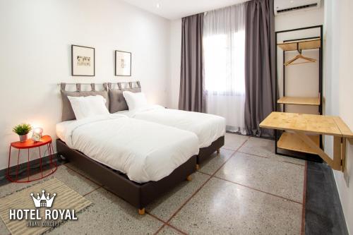 a hotel room with a large bed and a table at Hôtel Royal Urban Concept in Fez