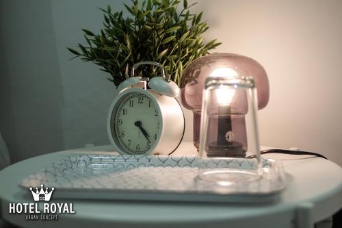 a clock and a lantern on a table with a plant at Hôtel Royal Urban Concept in Fez