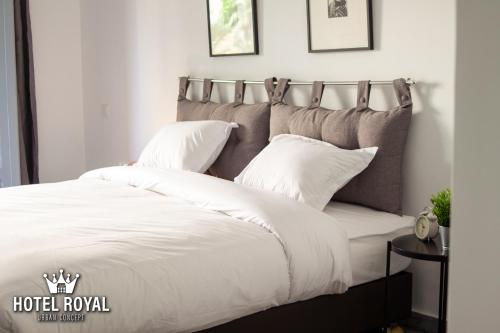 a bedroom with a bed with white sheets and pillows at Hôtel Royal Urban Concept in Fez