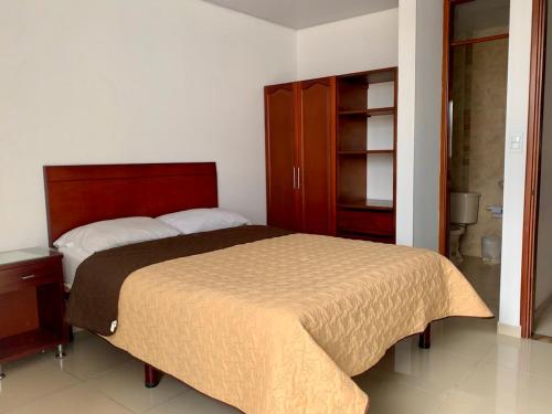 1 dormitorio con 1 cama grande y armario en Hotel Universal, en Duitama