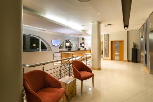 a lobby with two chairs and a counter at Holiday Inn Express Cape Town City Centre by IHG in Cape Town