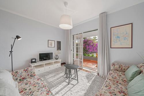 a living room with a couch and a tv and a table at Garajau I by An Island Apart in Caniço